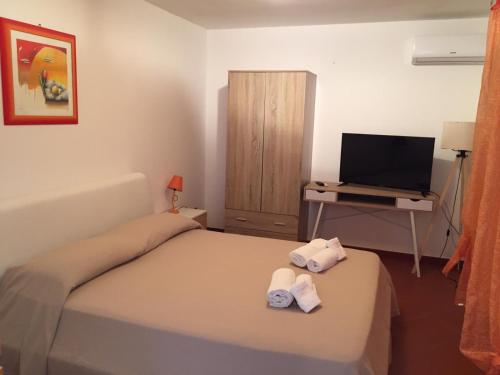 マリネッラにあるLa casa di Martaの小さなベッドルーム(ベッド1台、テレビ付)