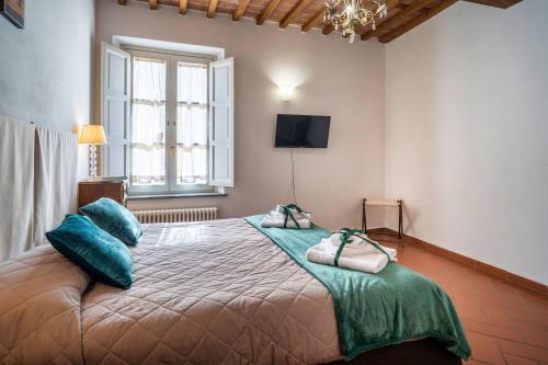 a bedroom with a large bed with blue pillows at La Dimora nell'Anfiteatro Superior room and apartment Self check in Elevator Air Conditioning in Lucca