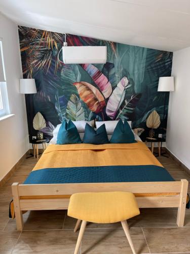 a bedroom with a bed with a tropical mural on the wall at Kertész Vendégház in Siófok