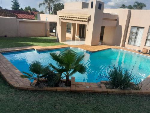 a swimming pool in front of a house at Merensky house in Roodepoort