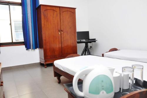 a hospital room with two beds and a cabinet at Sea View Hotel in Colombo