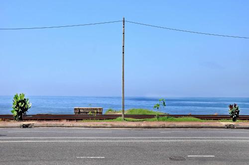 an empty road with the ocean in the background at Sea View Hotel in Colombo