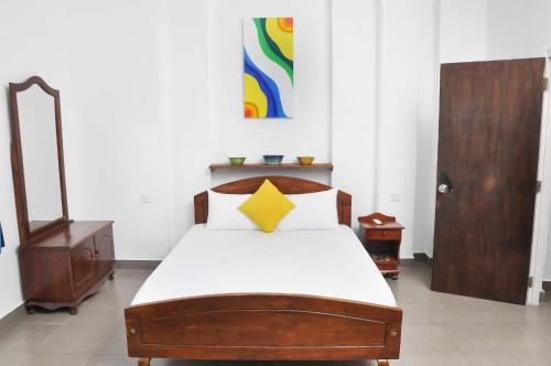 a bedroom with a wooden bed with a yellow star on it at Sea View Hotel in Colombo