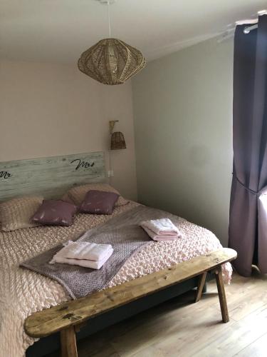 une chambre avec un lit avec deux serviettes dessus dans l'établissement Le Burin des Rosiers, à Olby