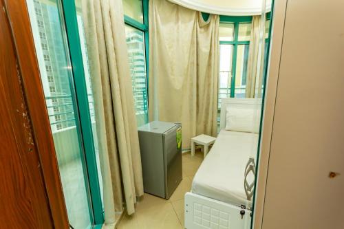 mały pokój z łóżkiem i oknem w obiekcie MC Budget Rooms for Girls Apartment Number 4202 w Dubaju