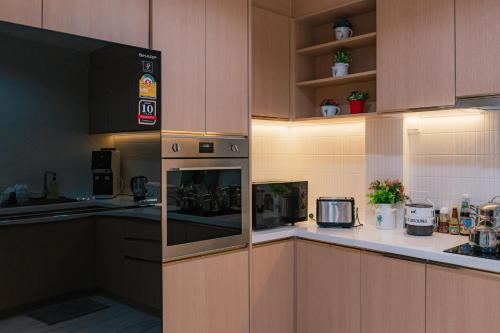 a kitchen with wooden cabinets and a stove top oven at MODERN - CITY CENTER, Phrom Phong BTS, Em District, Terminal 21, MAX 14 People in Bangkok