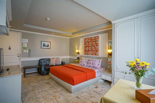 a bedroom with a bed and a chair in it at At Pingnakorn Nimman Hotel in Chiang Mai