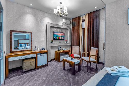 a hotel room with a bed and a table and a desk at Manor Luxury Hotel Baku in Baku