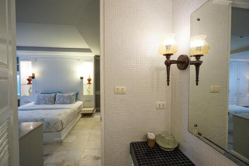 a bedroom with a bed and a mirror in a room at At Pingnakorn Nimman Hotel in Chiang Mai