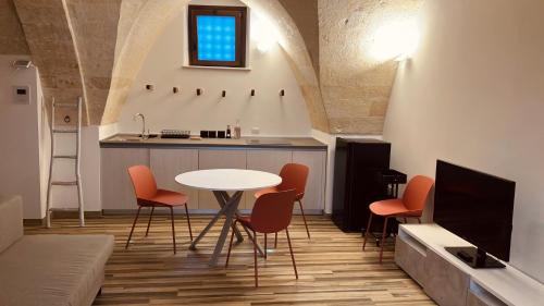 sala de estar con mesa y sillas y cocina en La Stalla, en Gravina in Puglia