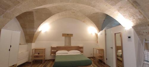1 dormitorio con 1 cama en una habitación con un arco en La Stalla, en Gravina in Puglia
