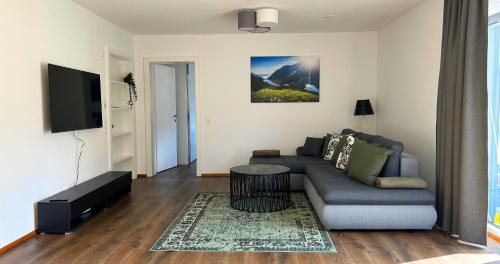 uma sala de estar com um sofá e uma televisão em streitbergers. Appartement em Maishofen