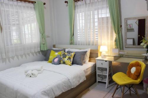 - une chambre dotée d'un lit avec des animaux rembourrés dans l'établissement The hand flower home, à Chum Phae