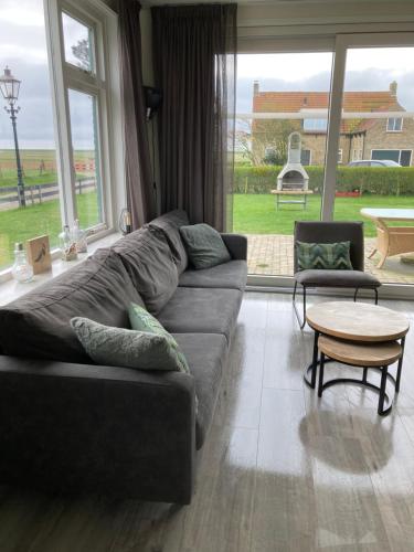 uma sala de estar com um sofá e uma mesa em Vissers Huus Hollum Ameland em Hollum