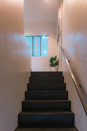 a stairway with a window and a plant at MODERN - CITY CENTER, Phrom Phong BTS, Em District, Terminal 21, MAX 14 People in Bangkok