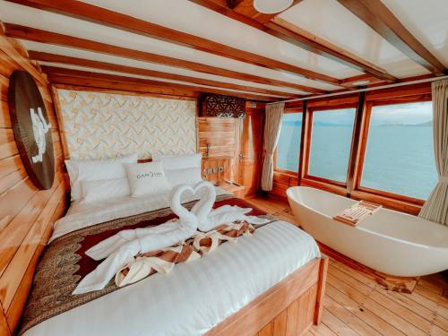a bedroom with a tub and swans on a boat at Dav-Venture in Labuan Bajo