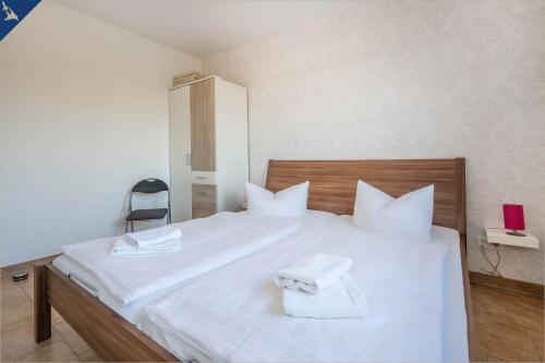 Un dormitorio con una cama blanca con toallas. en Ferienwohnung Sonneneck, en Kachlin