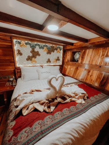 a swan laying on a bed with a blanket at Dav-Venture in Labuan Bajo