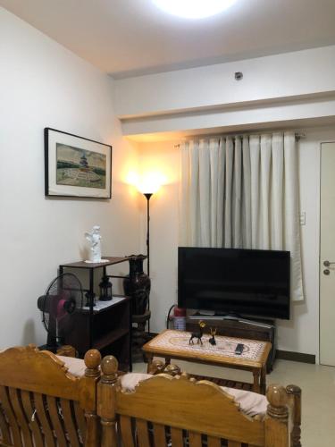 een woonkamer met 2 bedden en een flatscreen-tv bij M&M Residence in Manilla