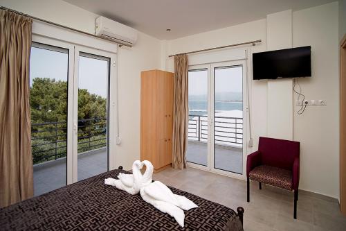 a bedroom with a bed with a towel animal on it at Karnagio Rooms in Kyparissia