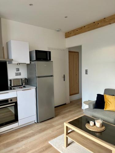 un salon avec un canapé et une cuisine dans l'établissement Appartement COSY proche commerces et Naval Group, à Cherbourg en Cotentin