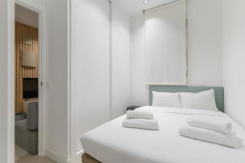 - une chambre blanche dotée d'un lit avec des draps et des oreillers blancs dans l'établissement Modern and cozy-1Bedroom 1Bathroom-Azca, à Madrid