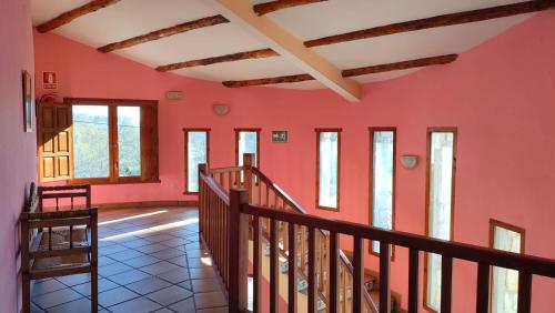 a room with red walls and wooden stairs at Alojamientos La Dehesa in El Berrueco