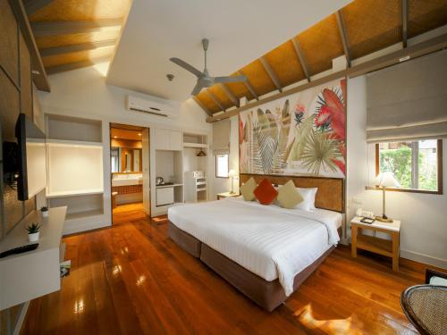 a bedroom with a large bed and a kitchen at Fisherman's Resort Haad Chao Samran in Haad Chao Samran