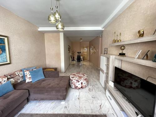 a living room with a couch and a fireplace at Late&Early Flight cozy Apartment in Nouaseur