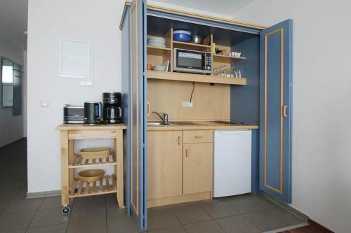 eine Küche mit einer Spüle und einer Mikrowelle in der Unterkunft Yachthafenresidenz - Wohnung 9102 / 878 in Kühlungsborn