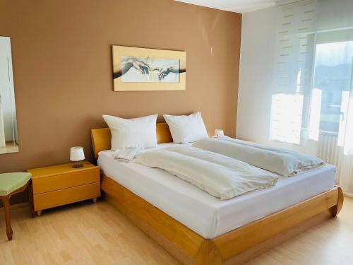 a bedroom with a bed with white sheets and a window at Weingut Raevenhof in Ayl