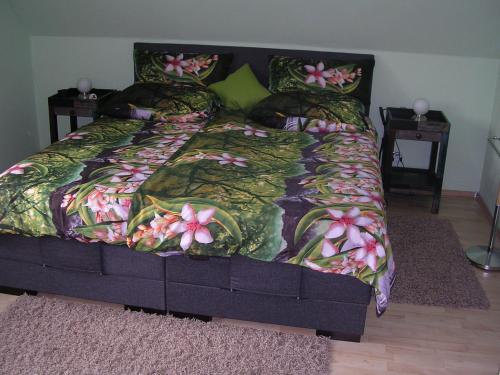 ein Bett mit einer Bettdecke und Blumen darauf in der Unterkunft Ferienwohnung Müller Bad Segeberg in Bad Segeberg