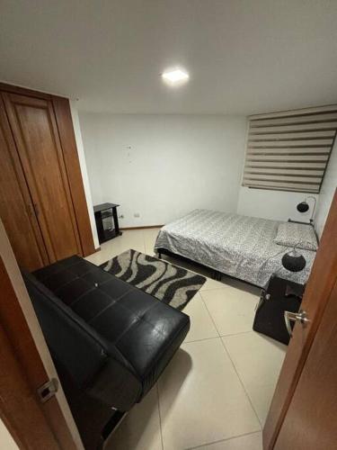 sypialnia z łóżkiem i czarnym skórzanym stołkiem w obiekcie Hermoso apartamento en Sabaneta w mieście Sabaneta