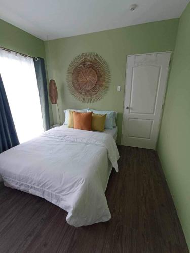 Un dormitorio con una gran cama blanca y una ventana en Urban Zen, en Calambá