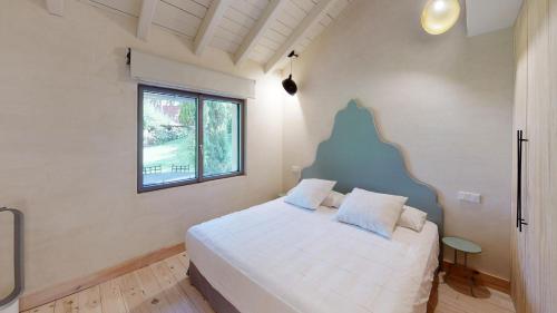 a bedroom with a white bed and a window at Libélula de El Vergel de Chilla in Candeleda