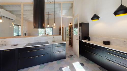 a large kitchen with blue cabinets and white counters at Libélula de El Vergel de Chilla in Candeleda