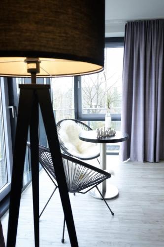 a table and a chair in a room with a window at Nordic Avantage Hotel in Kiel