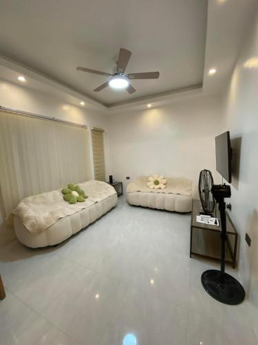 sala de estar con 2 camas y ventilador de techo en Mountain View, en Binangonan