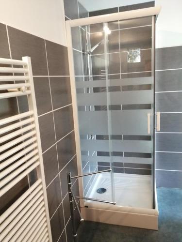 une douche avec une porte vitrée dans une salle de bain dans l'établissement la fenass, à Noailhac