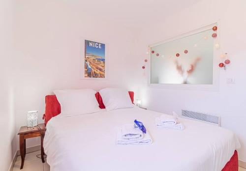 a bedroom with a white bed and a mirror at Pretty T2 In Peace With Parking Menton in Menton