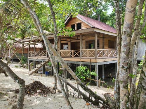 a wooden house in the middle of trees at Sunset Surfing Villas Mentawai in Tuapejat