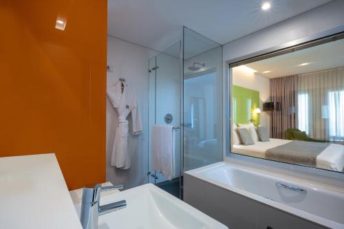 La salle de bains est pourvue d'un lavabo et d'un grand miroir. dans l'établissement Crowne Plaza Tel Aviv City Center, an IHG Hotel, à Tel Aviv