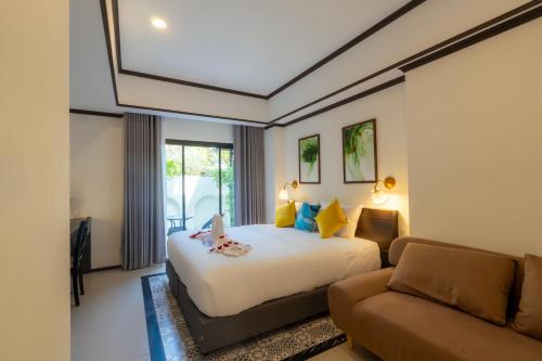 チェンマイにあるLe ville lanna Chiang Mai Gate Old Town Hotelのベッドとソファ付きのホテルルーム
