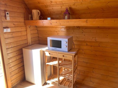 a small room with a microwave and a refrigerator at Les Hébergements Insolites Catalans in Saint-André