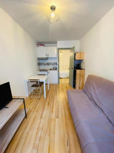 ein Schlafzimmer mit einem Bett und einem Tisch sowie eine Küche in der Unterkunft Studio in Cauterets