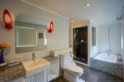 a bathroom with a sink and a toilet and a tub at At Pingnakorn Nimman Hotel in Chiang Mai