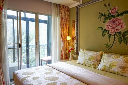 a bedroom with a bed with a flower painting on the wall at At Pingnakorn Nimman Hotel in Chiang Mai