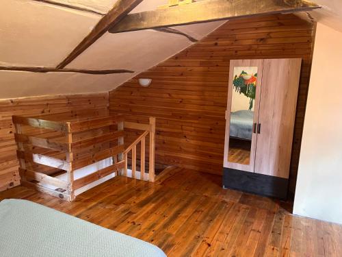 a bedroom with wooden walls and a staircase in a room at Le col de Perjuret in Fraissinet-de-Fourques