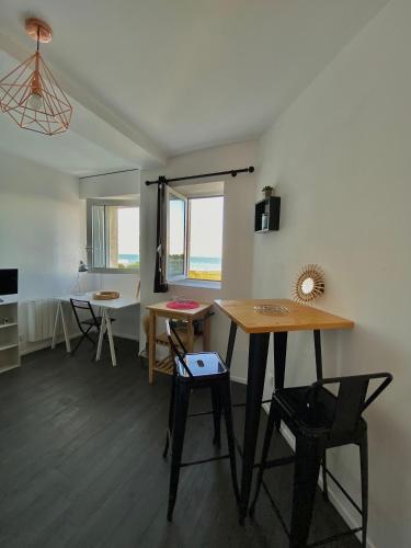 une pièce avec une table, des chaises et une fenêtre dans l'établissement Magnifique studio La Rochelle vue mer, à La Rochelle