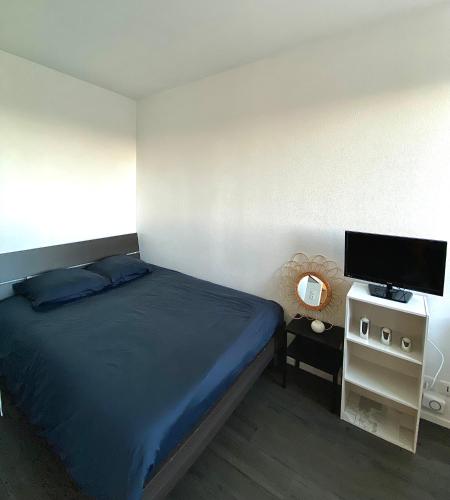 une chambre avec un lit et une télévision à écran plat dans l'établissement Magnifique studio La Rochelle vue mer, à La Rochelle